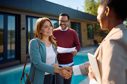 Couple smiling while shaking hands with their Lavallette real estate agent
